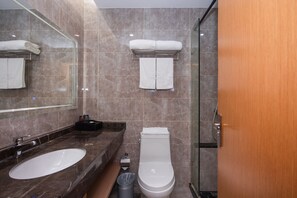 A modern bathroom with a marble sink, a toilet, and a glass shower enclosure. - Shanghai Future Shangju Hotel (Shanghai)