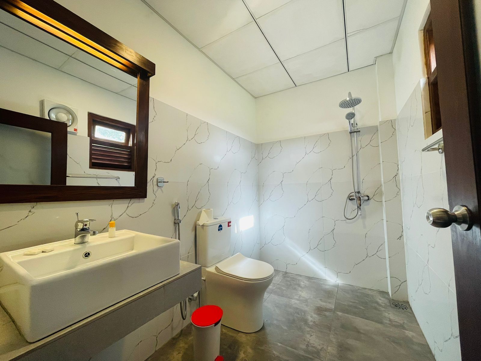 A bathroom with a white sink, toilet, and shower.