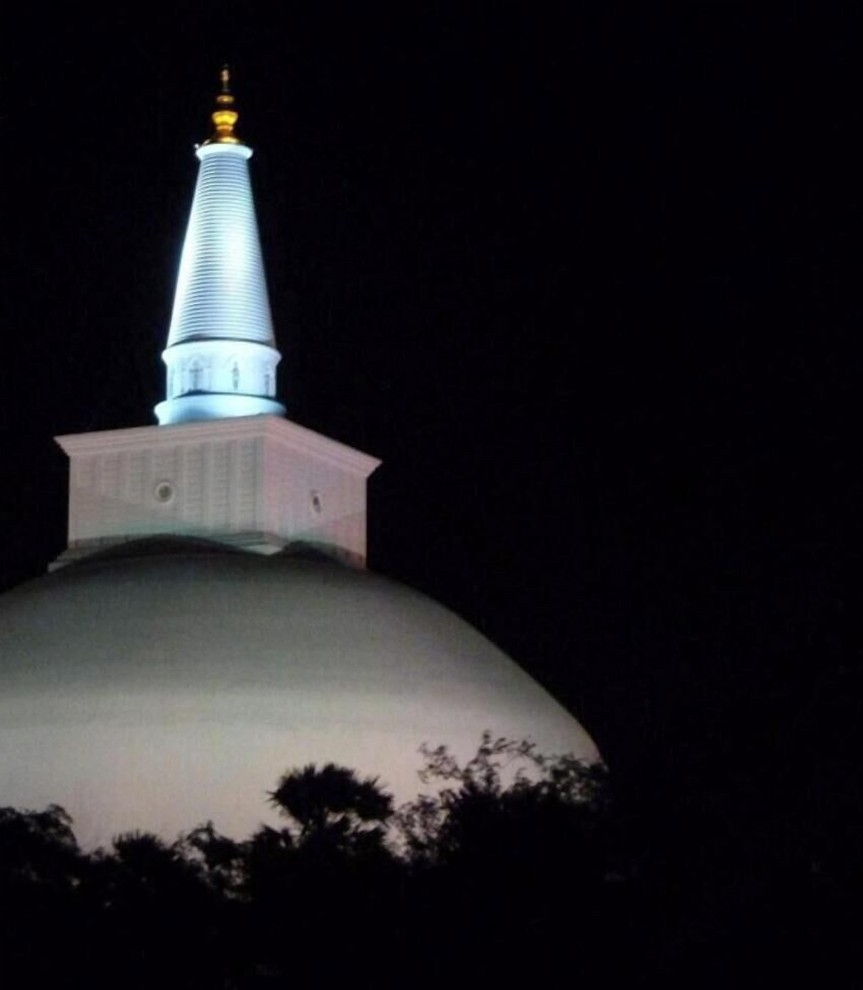 A dome-shaped building with a spire and a smaller structure on top.