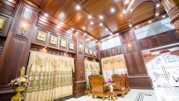 Una habitación lujosa con paneles de madera, cortinas ornamentales y una cama grande.