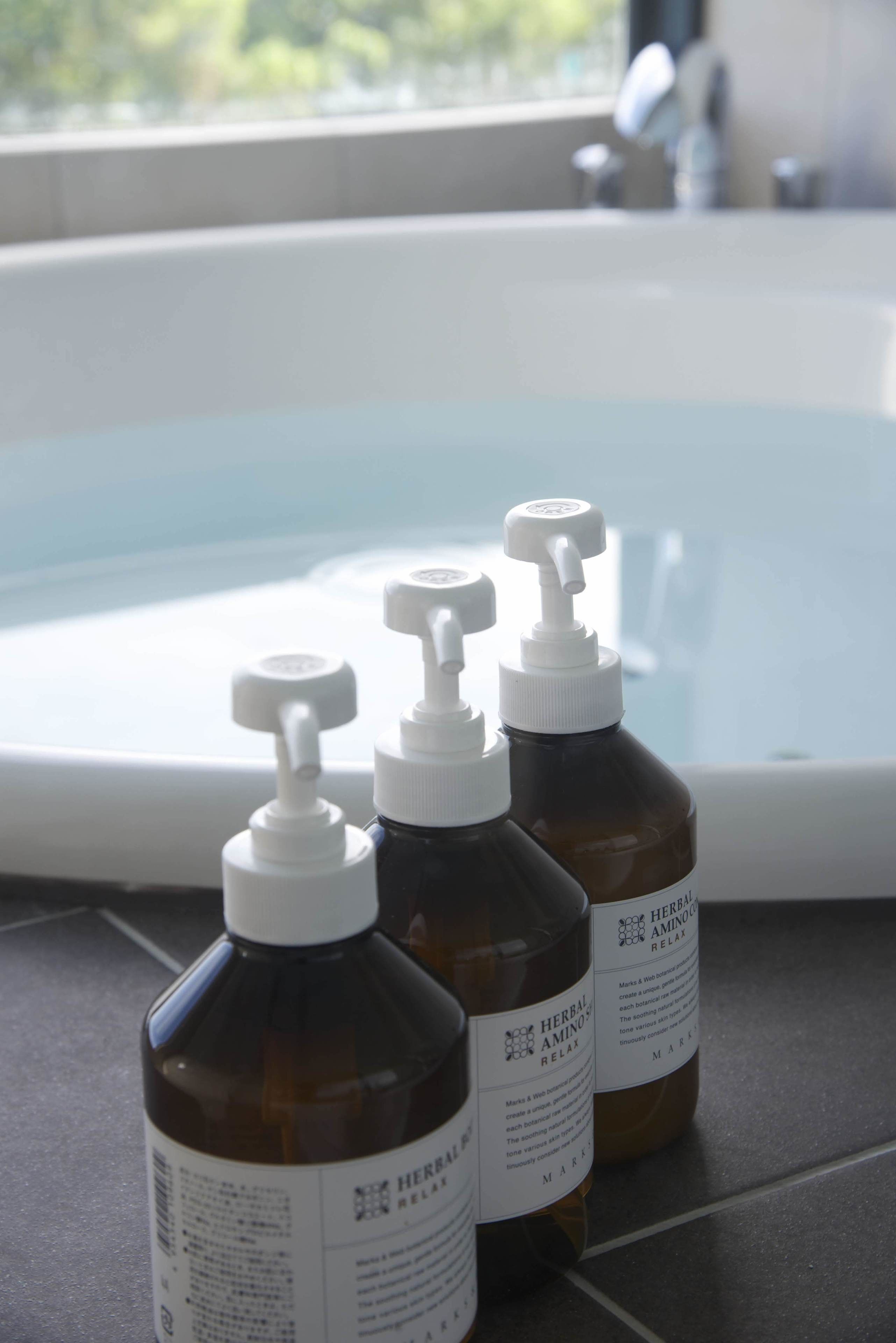 Tres botellas de 'Herbal Amino Relax' junto a una bañera.