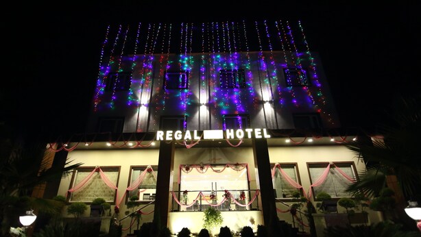 Exterior del Hotel Regal con señalización iluminada y decoración festiva.