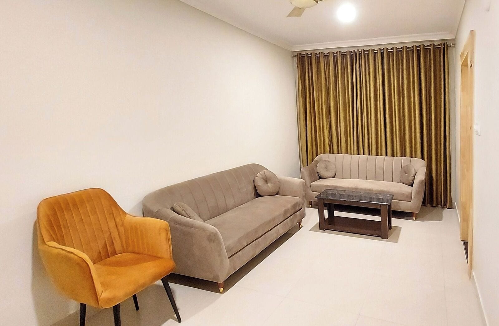 A living room with two sofas, a coffee table, and a single armchair.