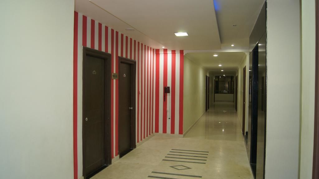 A hotel corridor with striped walls, doors, and a patterned floor.