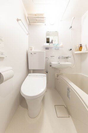 Une petite salle de bain comprenant des toilettes, un lavabo et une baignoire.