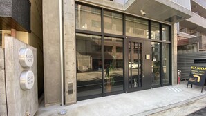 A hotel entrance with a glass door, a security camera above, and a sign indicating the hotel's name. - KAMON HOTEL Seto (Hiroshima)