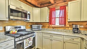Una cucina dotata di piano cottura, forno, microonde e tostapane.