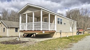 Ein eingeschossiges Haus mit einer Veranda und einer kleinen angebauten Garage.