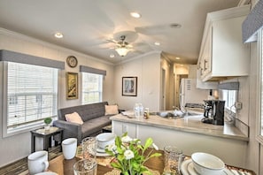 A modern kitchen with a central island, a dining area with a wooden table, and a living room with a sofa. - Clydesdale Cottage · Luxury Poconos Stay Near NYC (Pleasant Mount)