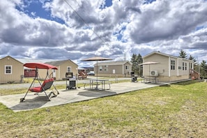 A residential area with mobile homes, a picnic table, and a swing chair. - Clydesdale Cottage · Luxury Poconos Stay Near NYC (Pleasant Mount)