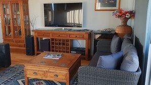 A living room with a sofa, coffee table, TV, and a cabinet. -  Quite harbour village. Close to beach, boat ramp and attractions  (Penneshaw)