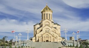 A large, historic building with a prominent tower and multiple flags.