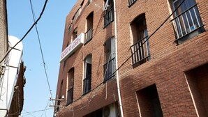 A red brick building with multiple windows and balconies. - Flat 013 (Tbilisi)