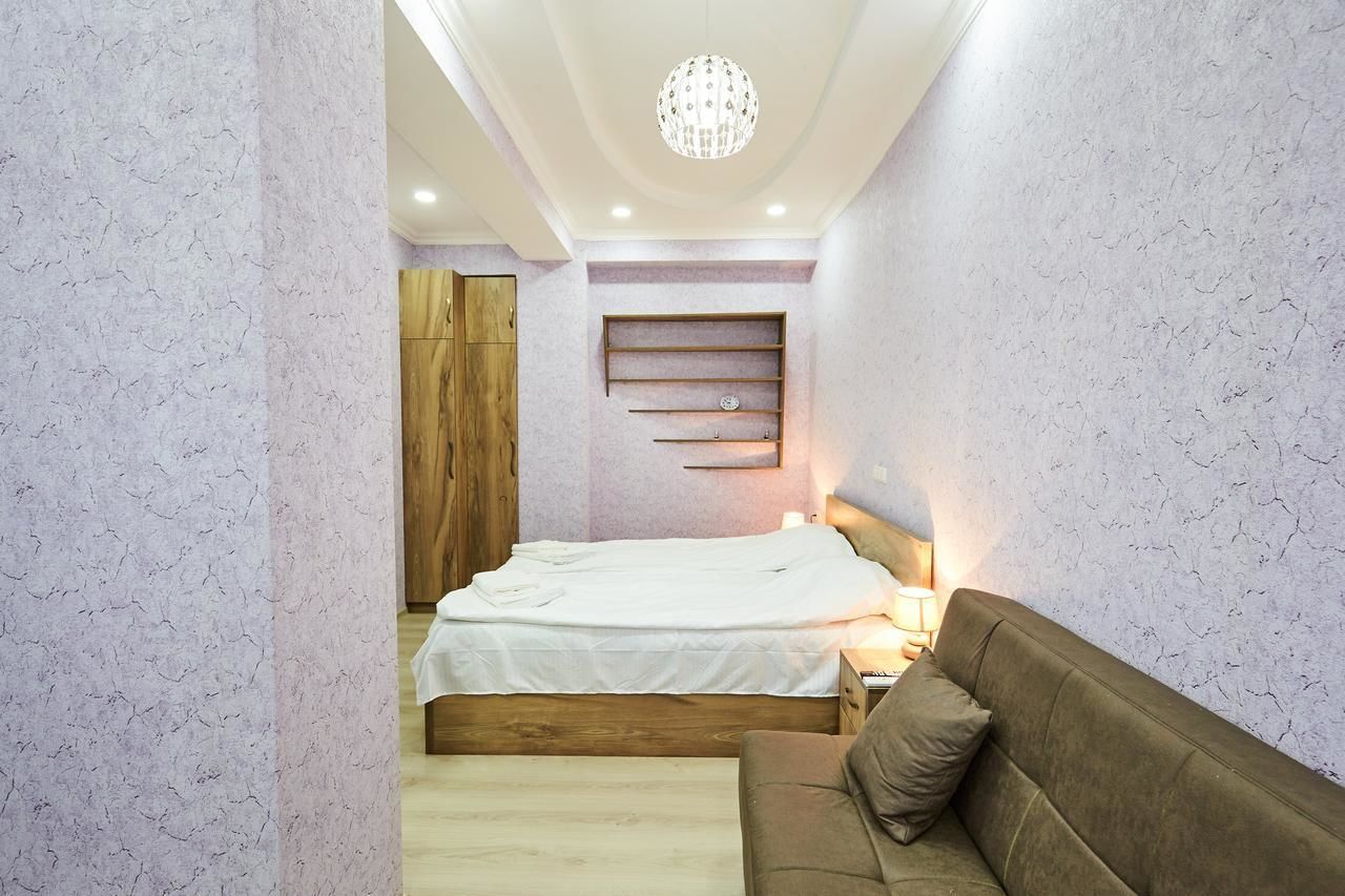 Ein Schlafzimmer mit einem Bett, einem Nachttisch, einer Lampe und einem Holzschrank.