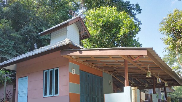 A two-story house with a covered porch, a large blue door, and a small balcony. - Farmstay at Pha Ma Chiangrai (Mae Chan)