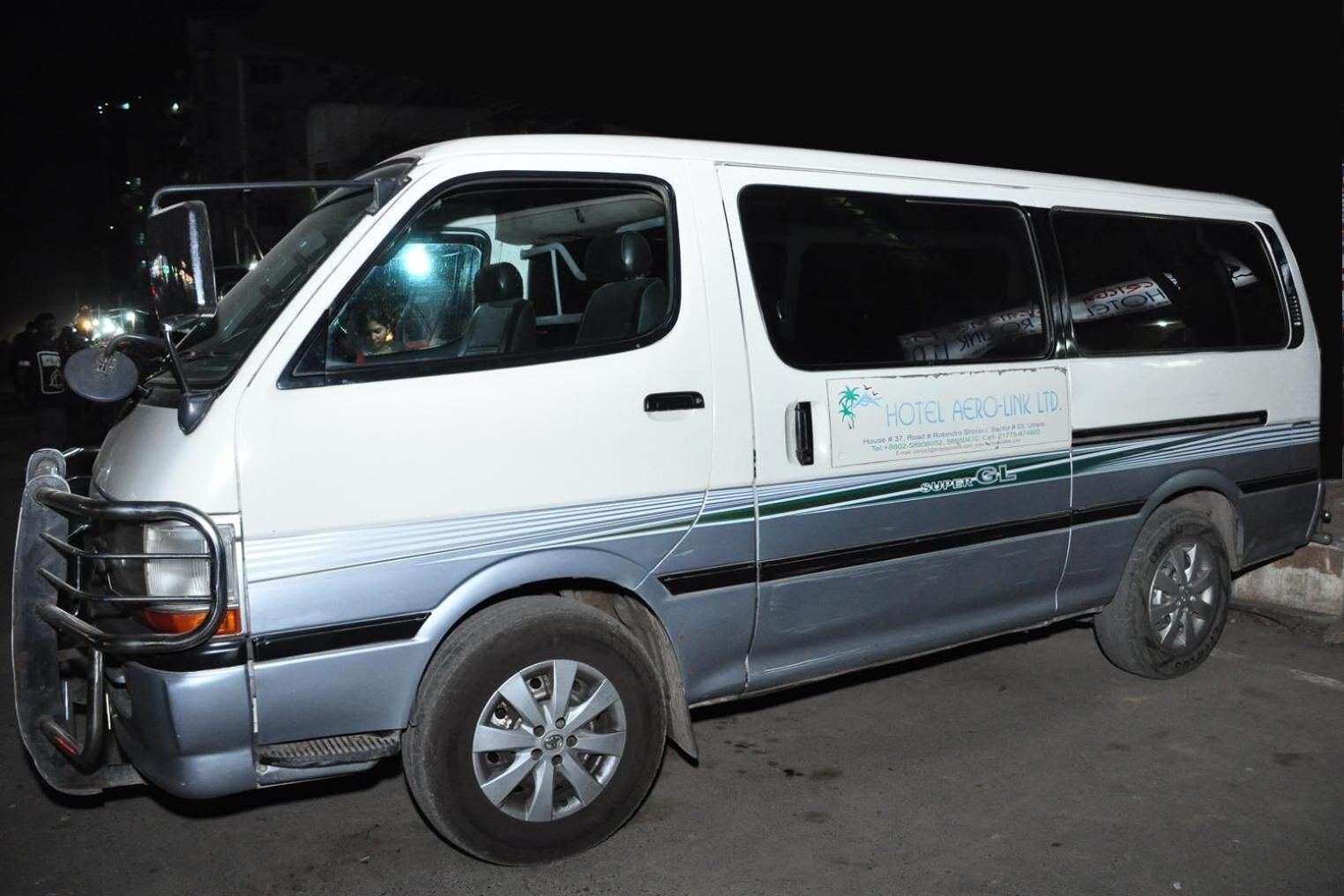 Una camioneta blanca y azul con un letrero que indica que es un vehículo de servicio de hotel.