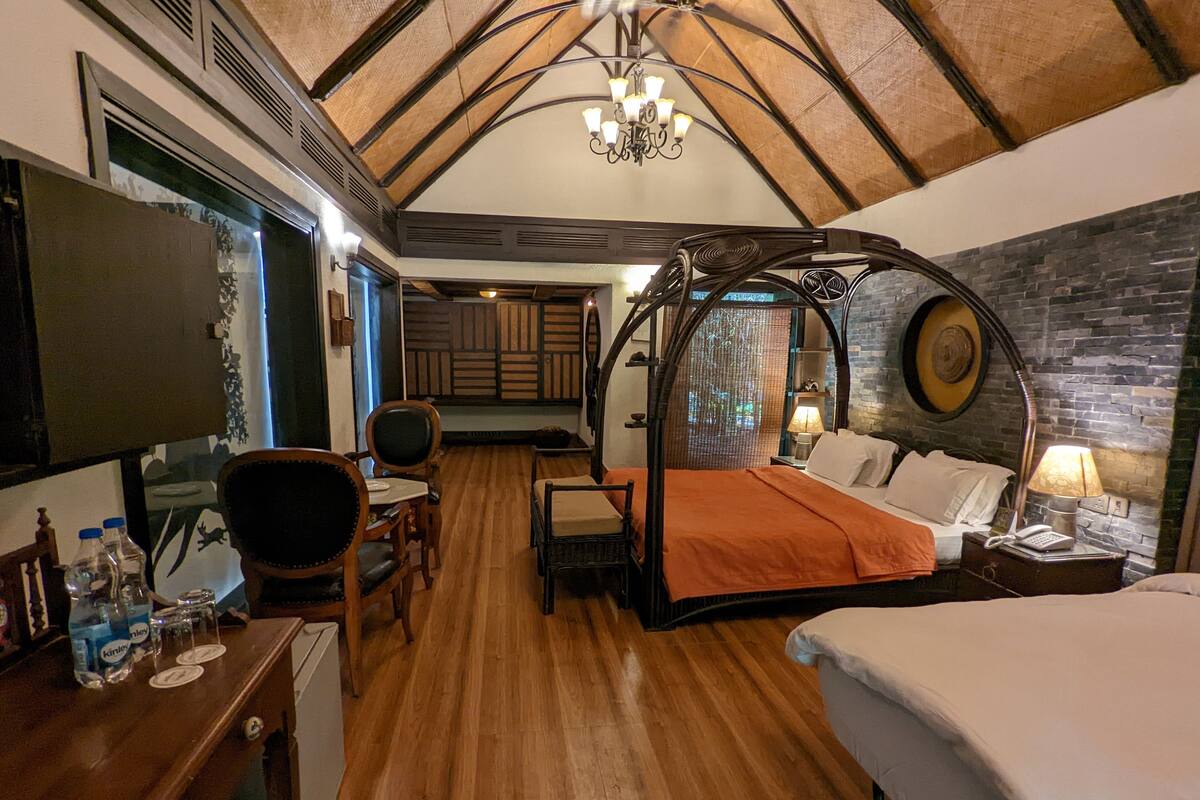 Ein gemütliches Zimmer mit einem Bett, einem Schreibtisch mit Stuhl, einem kleinen Tisch und einem Fernseher.