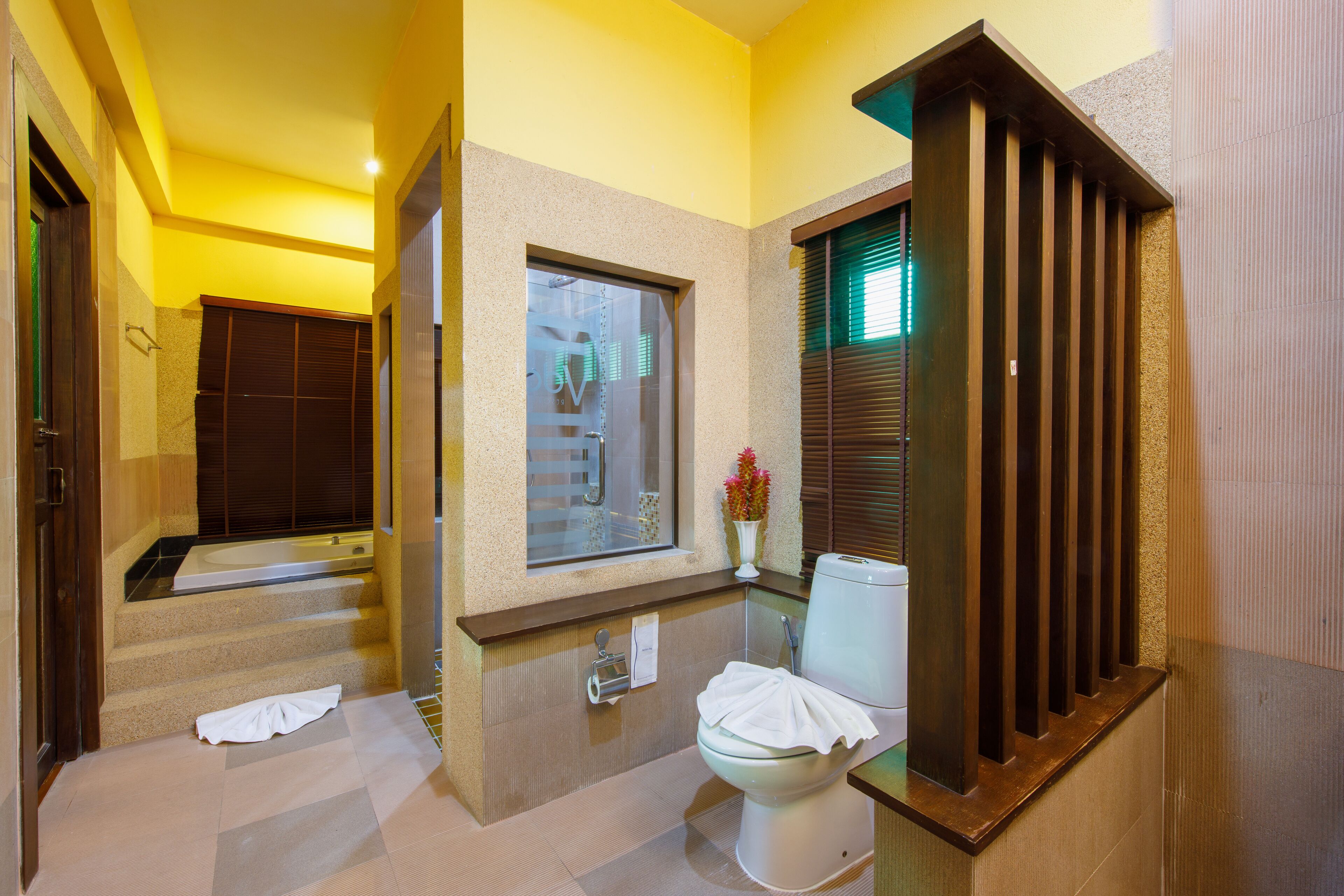 A modern bathroom with a bathtub, toilet, and shower area.