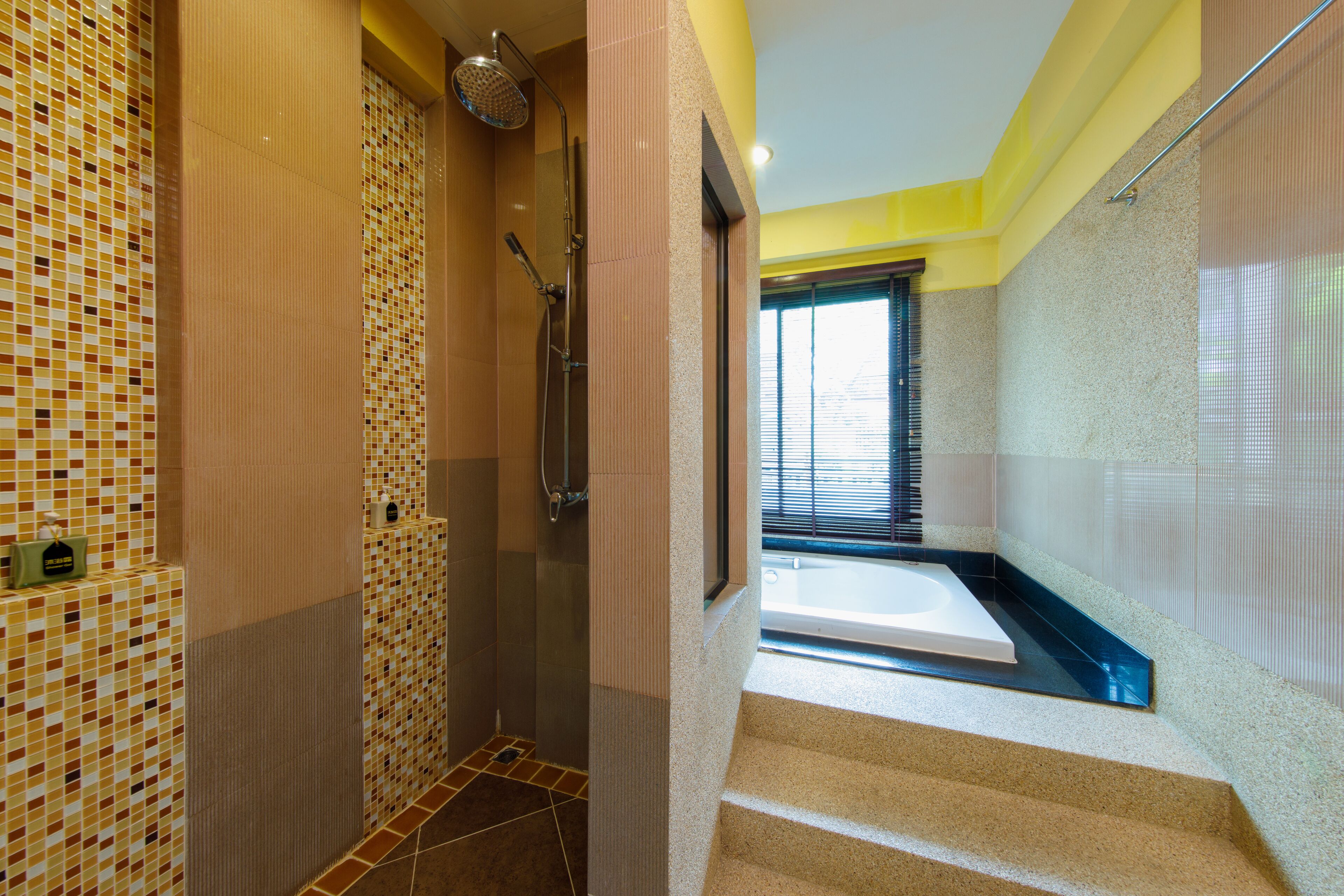 A modern bathroom with a shower, a bathtub, and a tiled wall.