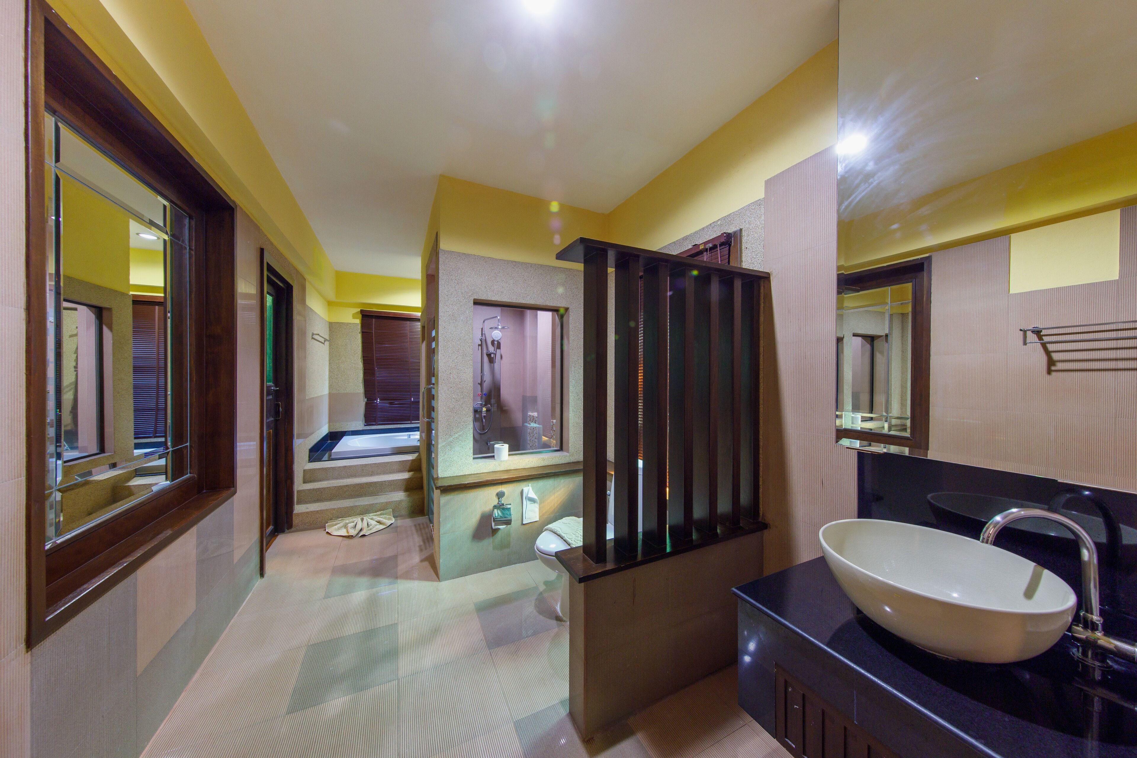 Un baño moderno con un lavamanos grande, un espejo y una zona de ducha.