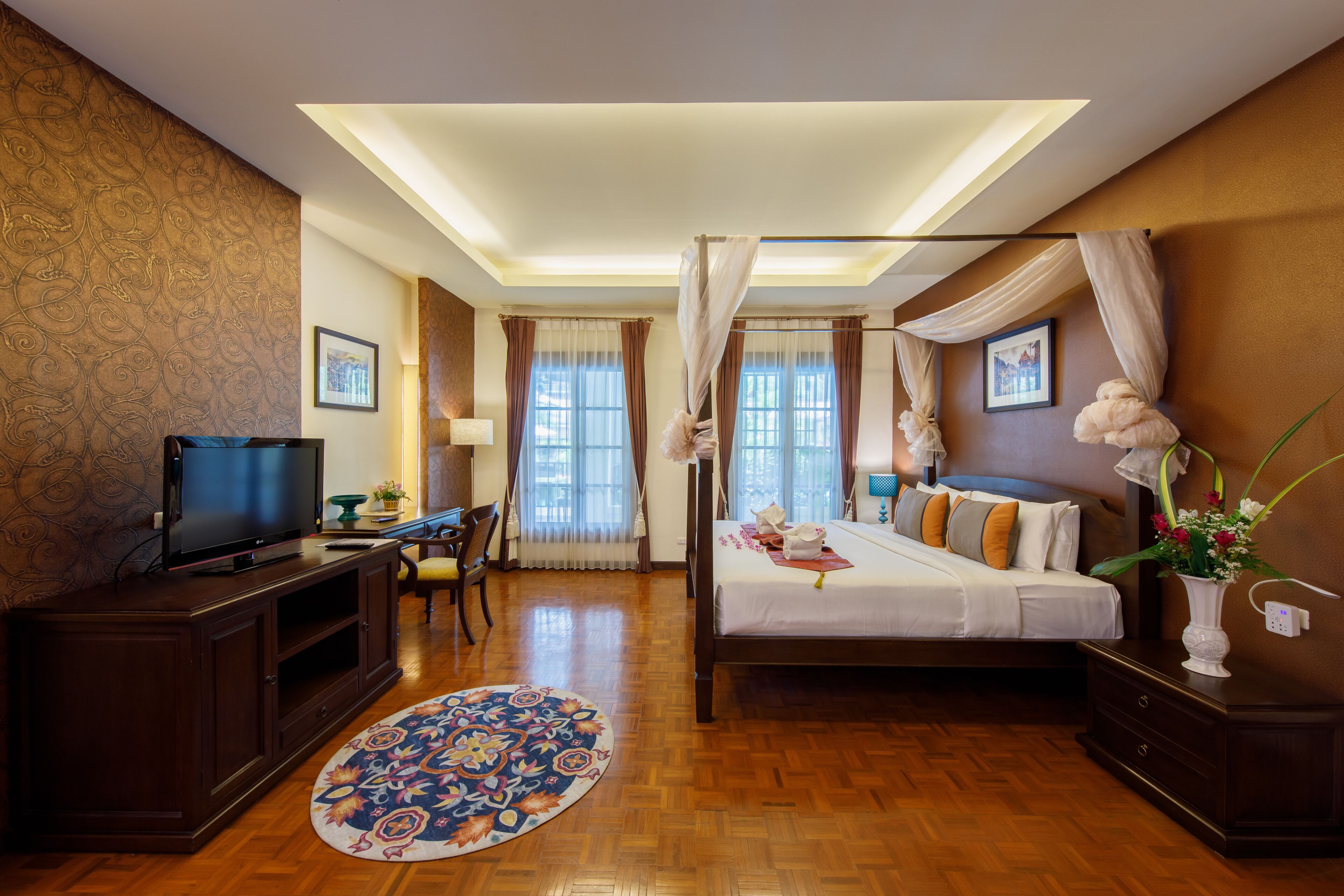 A hotel room with a bed, a TV, a desk, and a chair.