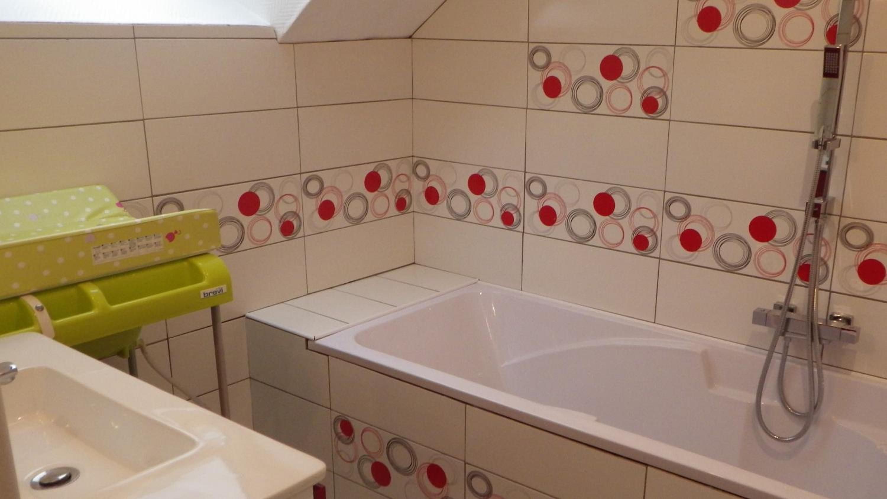 Een badkamer met een wit bad, een douche en een wastafel.