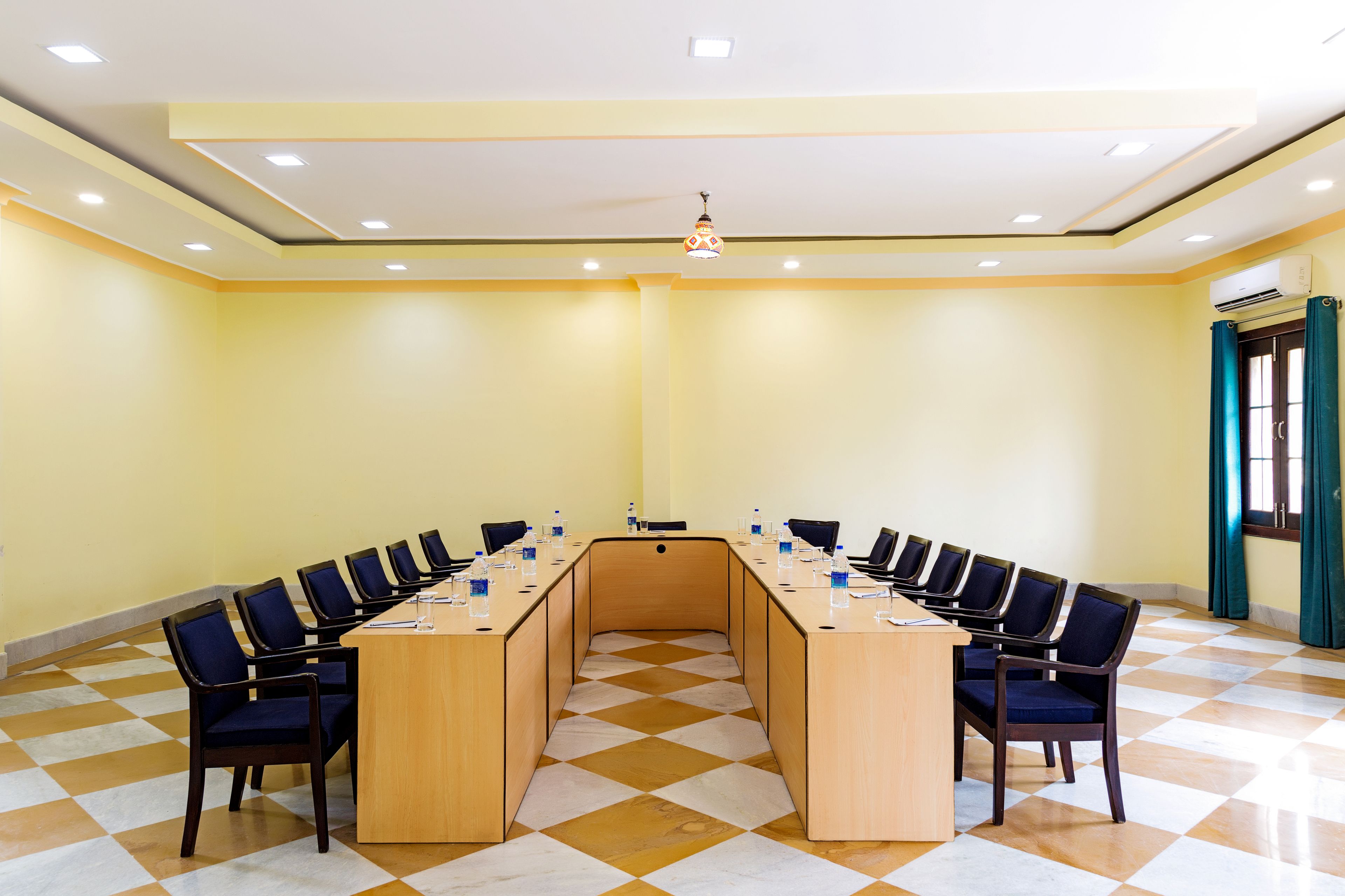 A conference room with a long table, chairs, and a ceiling light.