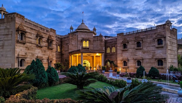 A historic building with a central courtyard, ornate arches, and a fountain. - Syna Heritage Hotel (Rajnagar)