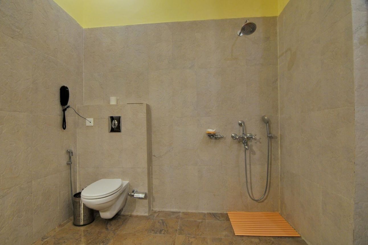 A small, modern bathroom with a toilet, bidet, and shower.