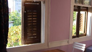 A room with a window, a table, two chairs, and a patterned rug. - Lotus Garden Hostel (Izmir)