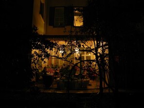 Una habitación tenuemente iluminada con una ventana, una silla y una mesa.