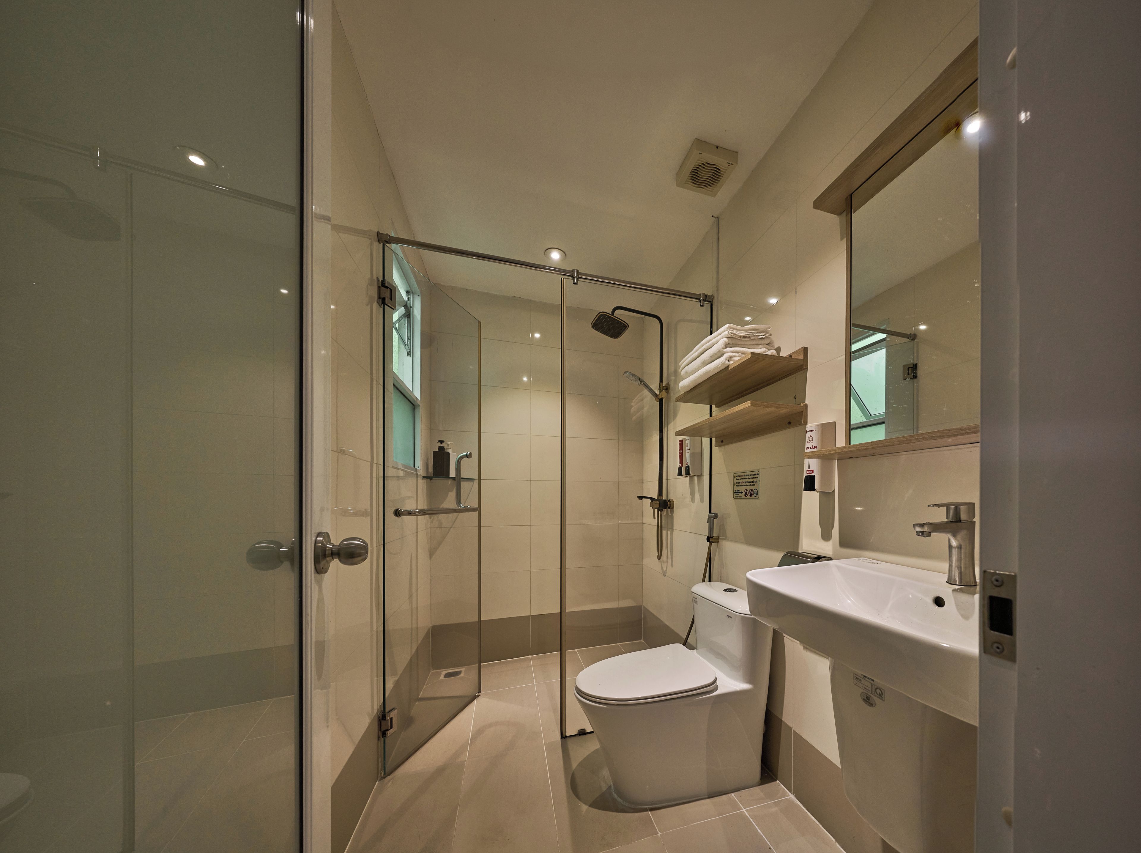Une salle de bain moderne avec une douche à parois de verre, des toilettes et un lavabo.