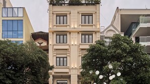 A hotel with a prominent 'HOTEL' sign at the top, a name sign below, and a modern facade with large windows and balconies. - Maison Truong Thinh Hotel by Urban B (Ho Chi Minh City)