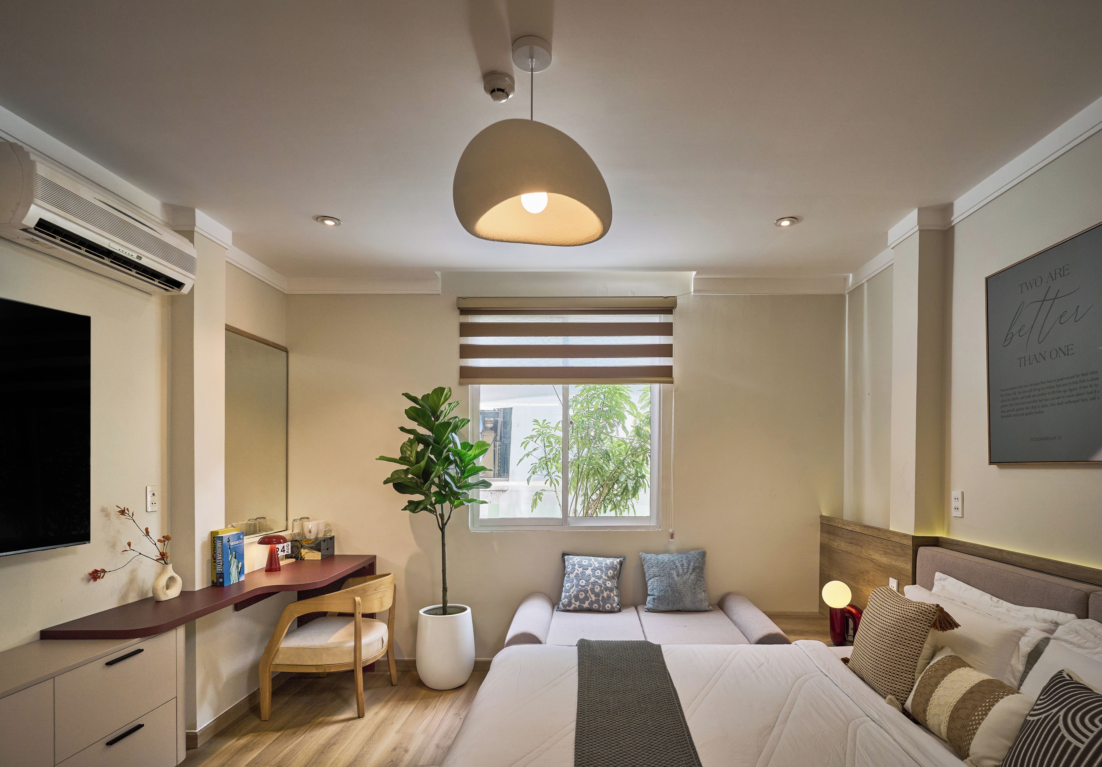 Een hotelkamer met een bed, nachtkastje, televisie en een groot raam.