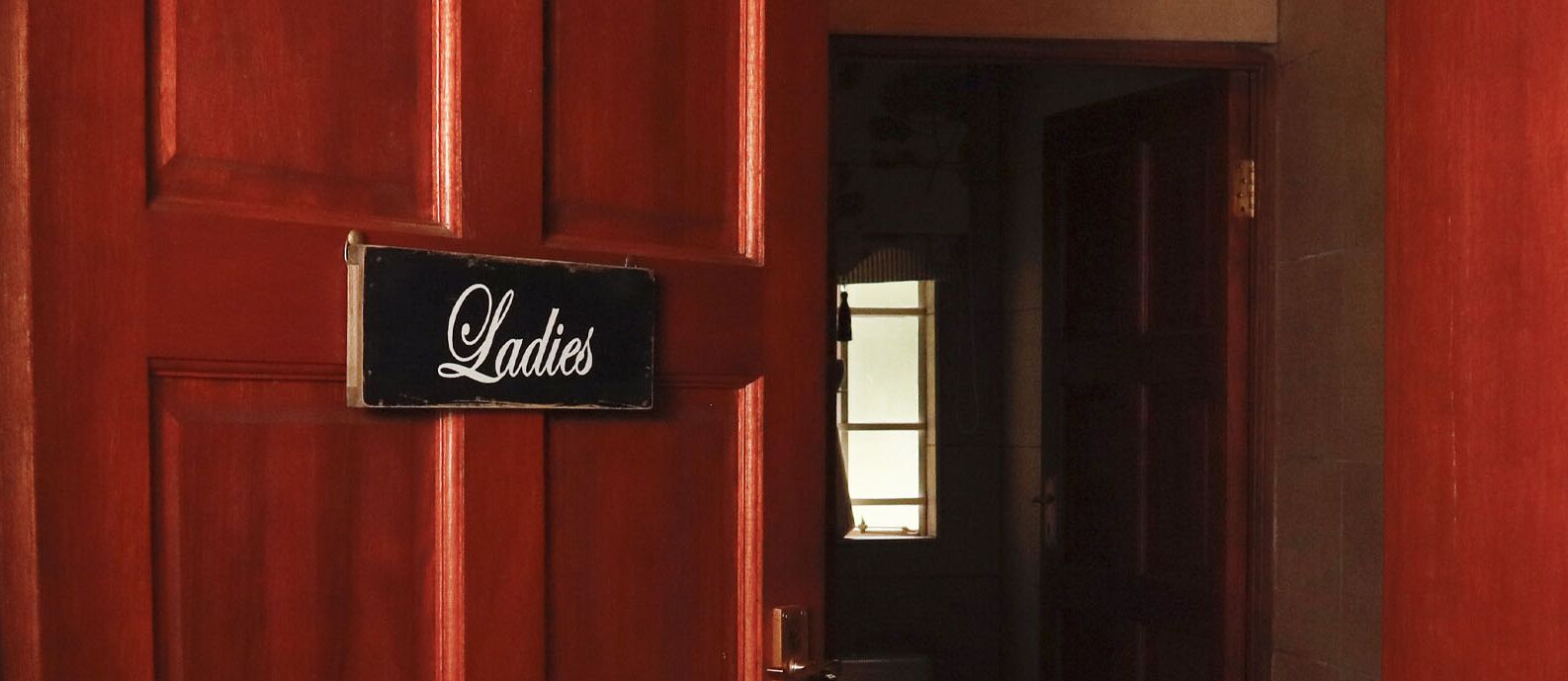 Una puerta de madera con un letrero que dice 'Ladies'.