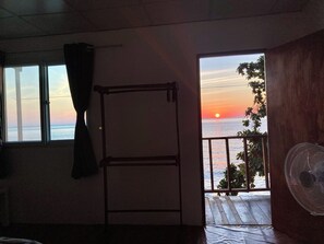 A room with a view of the sunset over the sea, a balcony with a railing, and a fan. - Ban Na White Sand Beach (Ko Chang)