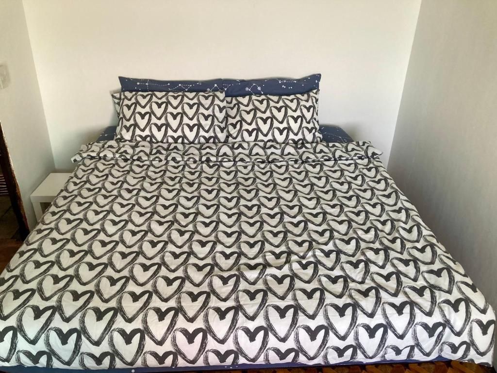 A bed with a patterned bedspread and matching pillows.