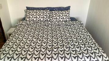 A bed with a patterned bedspread and matching pillows.