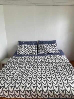 A bed with a patterned bedspread and two pillows with a geometric design. - Ban Na White Sand Beach (Ko Chang)