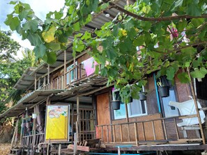A wooden house with multiple levels, a balcony, and hanging plants. - Ban Na White Sand Beach (Ko Chang)