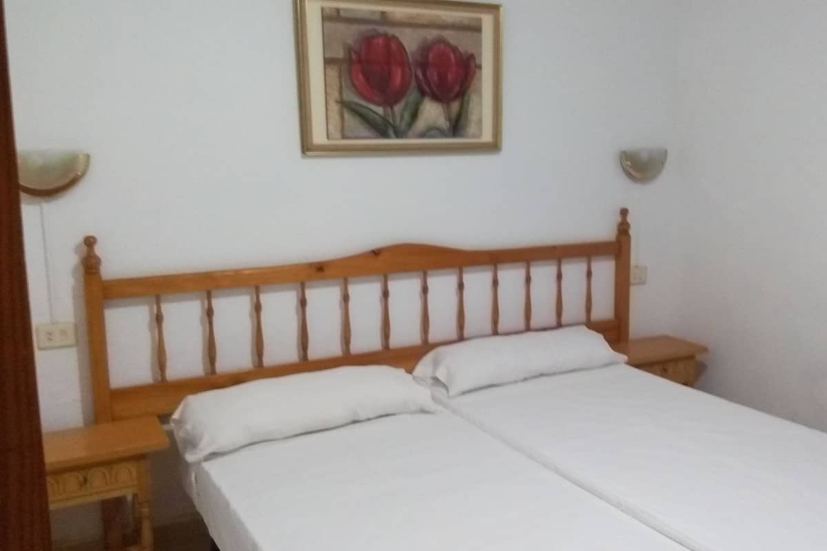 Tabla de planchar con plancha y ropa de cama