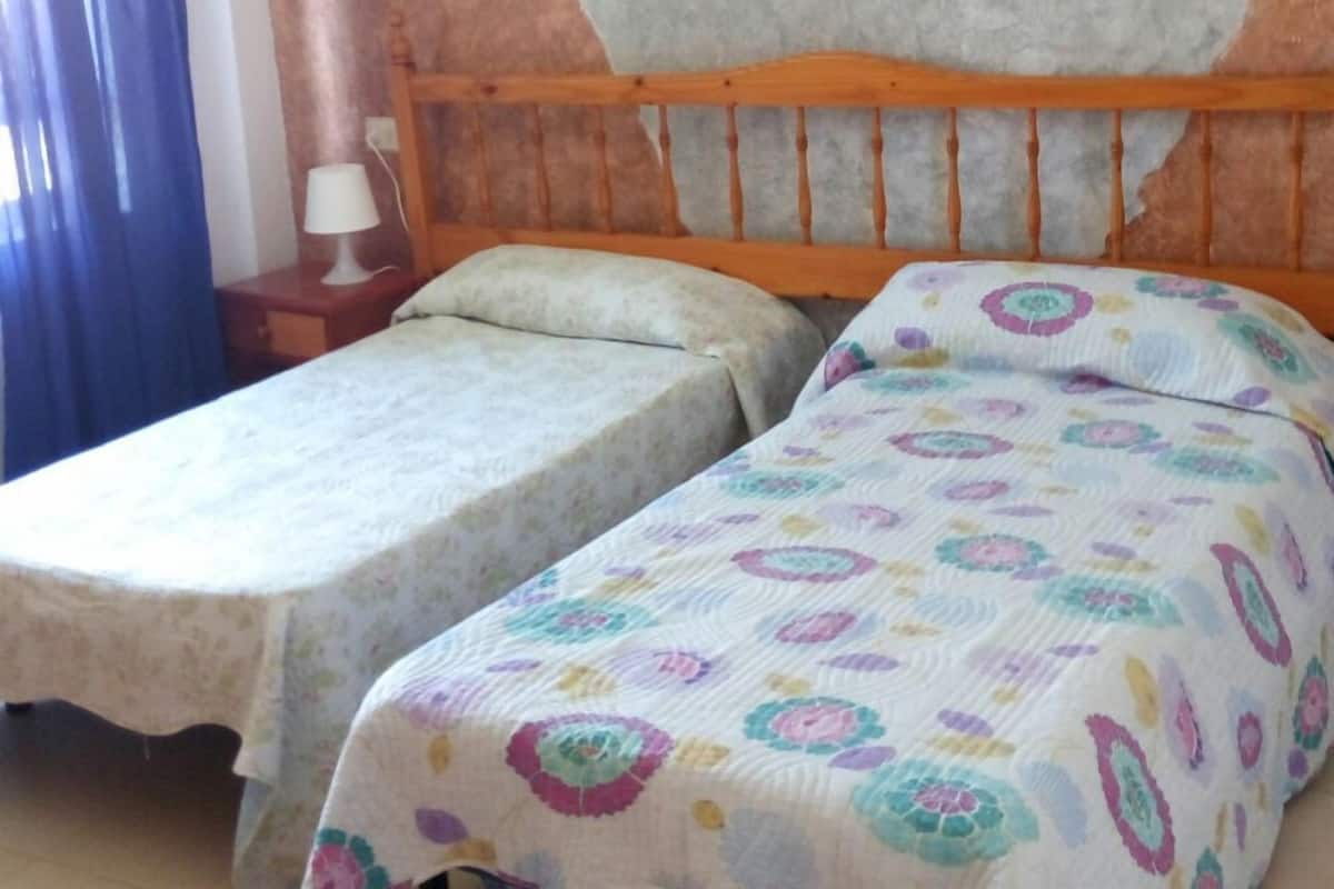 Tabla de planchar con plancha y ropa de cama