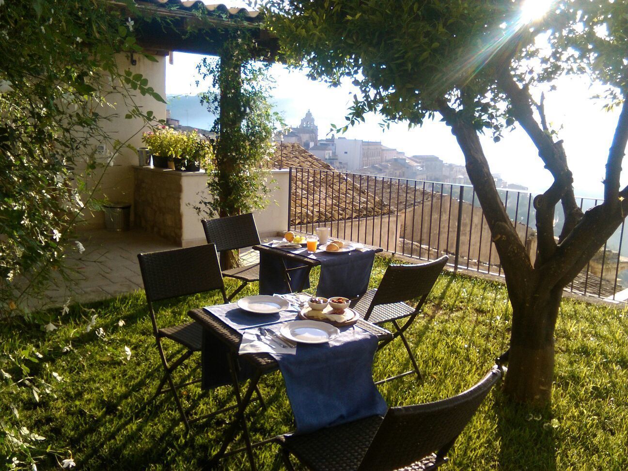 Un espace de restauration en plein air avec une table dressée pour deux personnes, entourée de chaises, et offrant une vue panoramique.