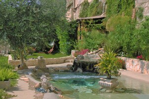 Een buitenzwembad, ligstoelen bij het zwembad