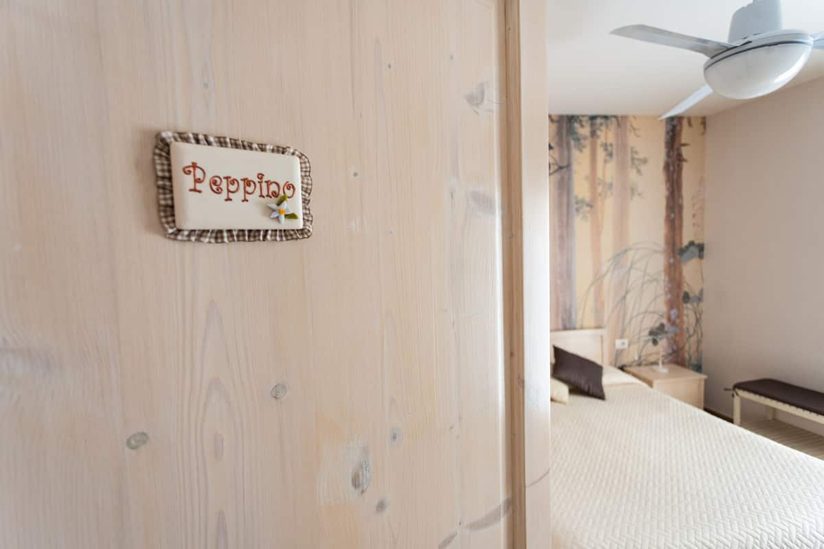 Eine Holztür mit einem Namensschild, auf dem 'Pepino' steht.
