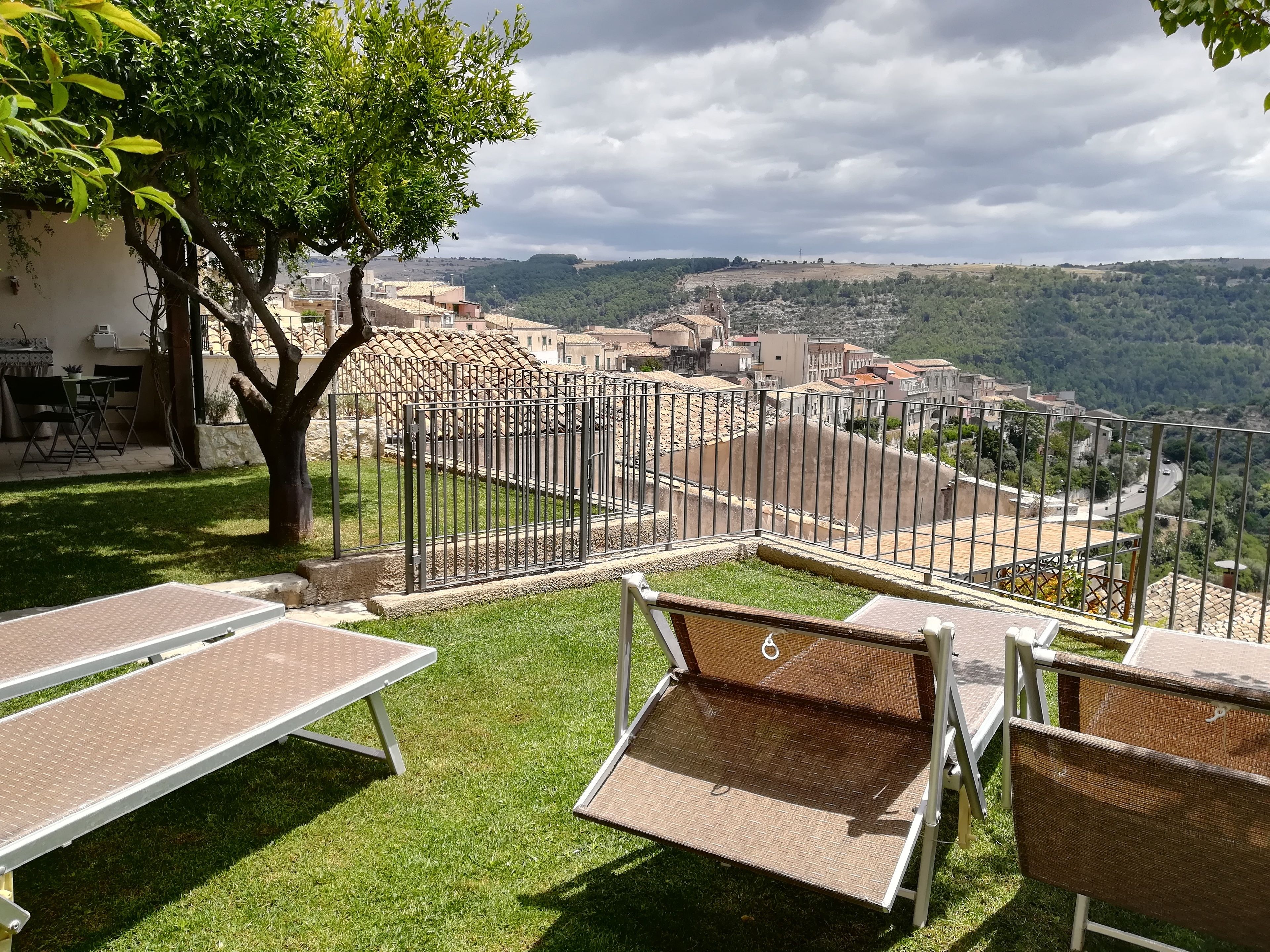 Une terrasse avec des places assises extérieures et une vue sur un village.
