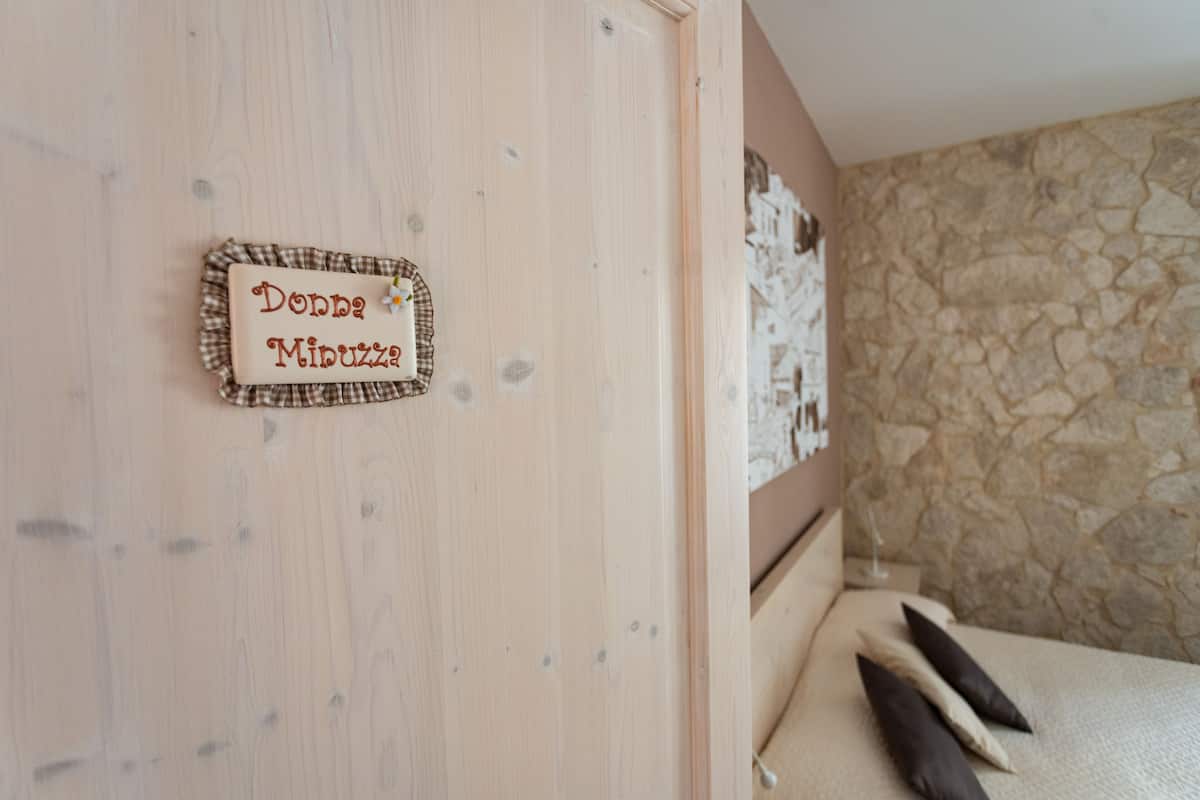 Eine Holzwand mit einem Schild, auf dem 'Donna Minuzzi' steht.