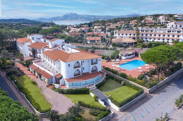 A large white building with multiple balconies and a swimming pool. - Hotel Cormorano (Arzachena)