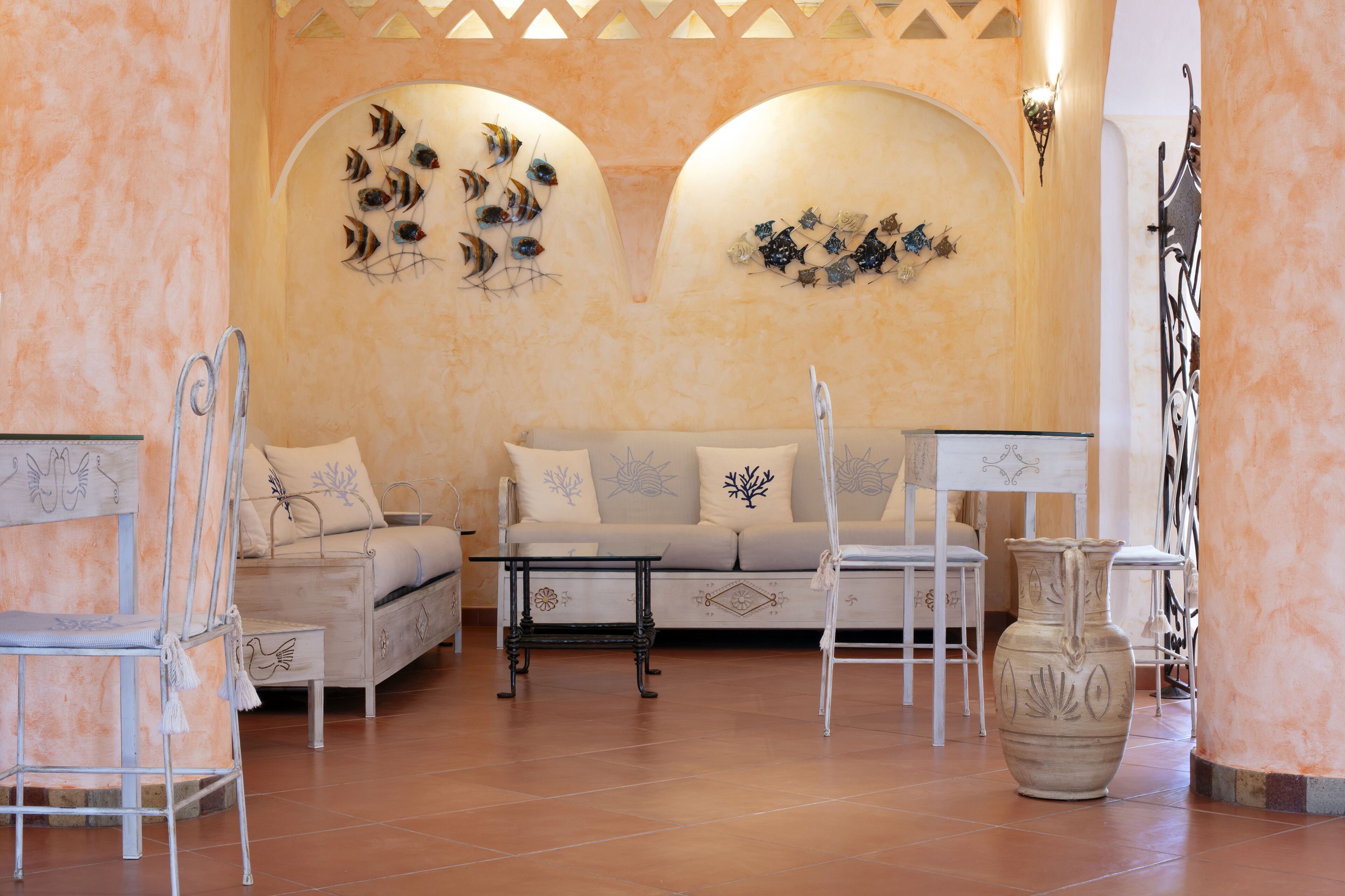 A room with a sofa, chairs, a table, and decorative wall art.