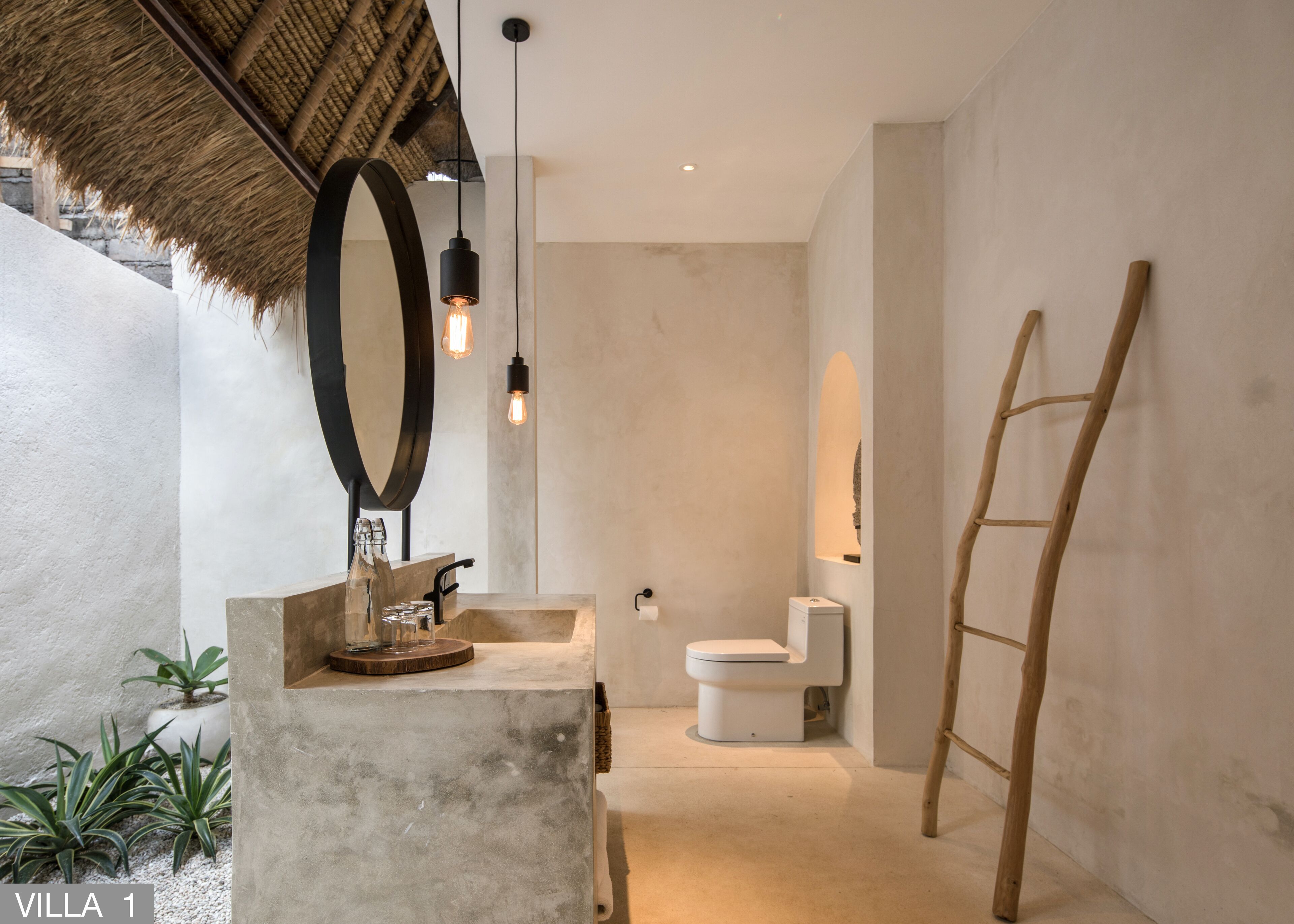 A modern bathroom with a concrete sink, a large mirror, and a wooden ladder.